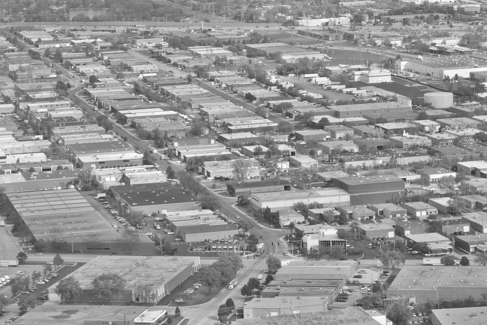 Aerial view of rows of single-story industrial and warehouse buildings with truck courts and parking in Elk Grove Village, Illinois.